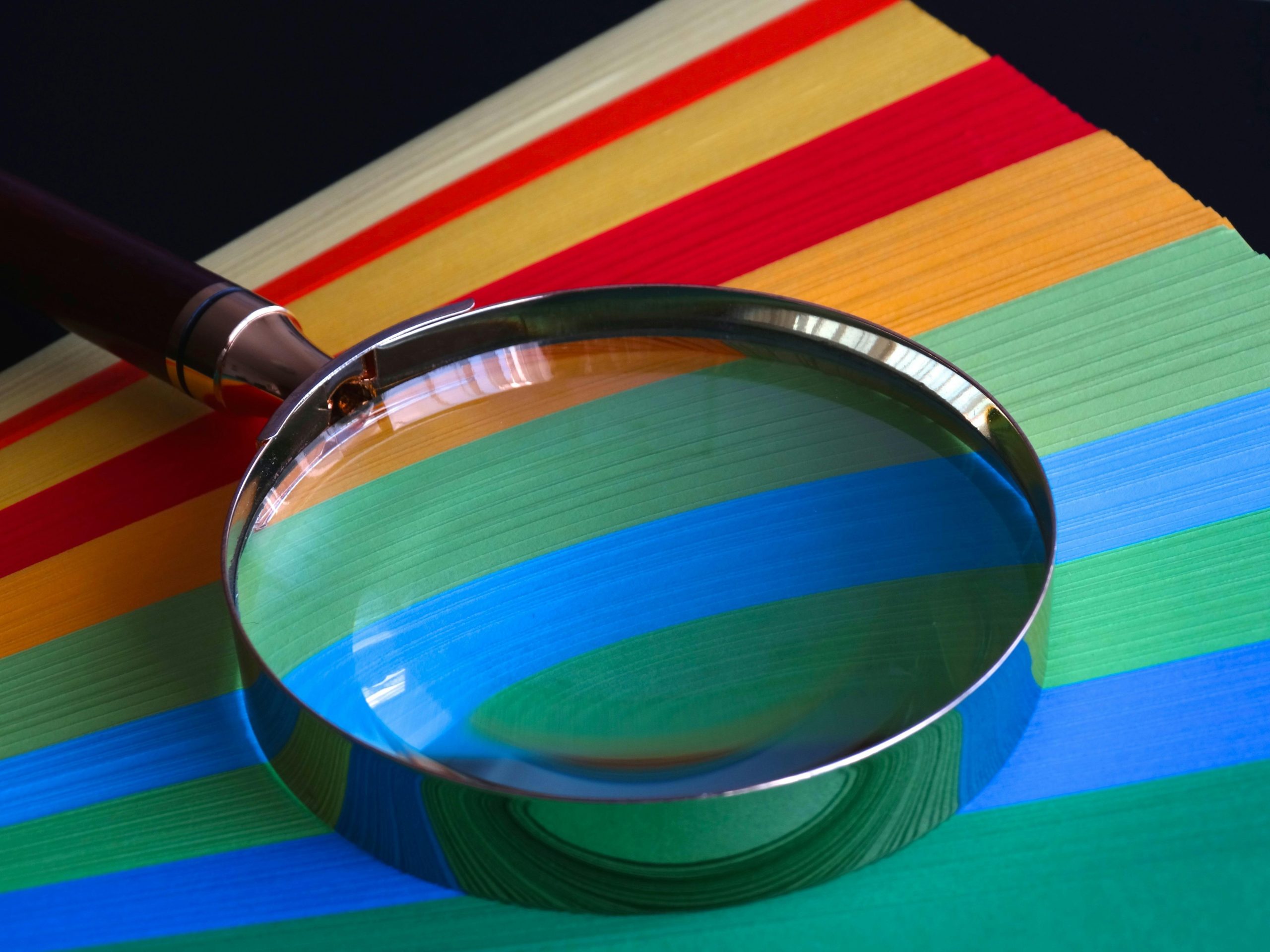 Illustration of a magnifying glass over a spreadsheet showing income vs. expenses