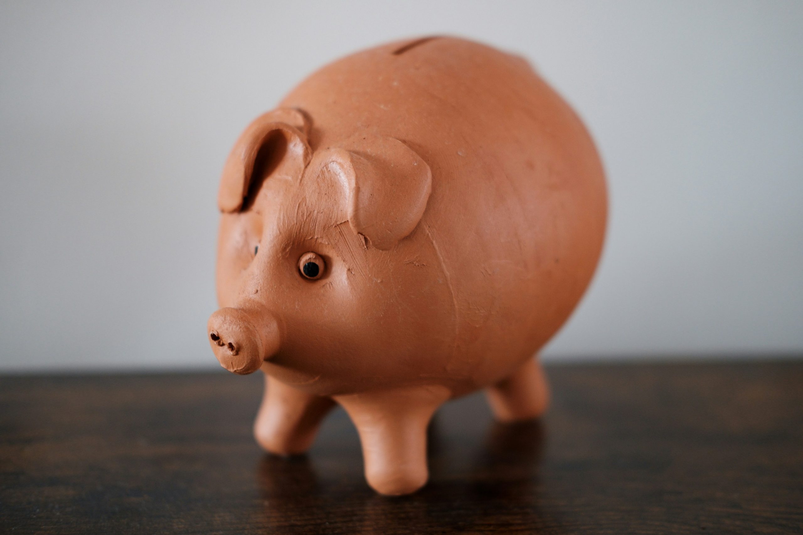 Here's a possible caption: a brown piggy bank sits on a table.